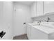 Bright laundry room featuring a white washer and dryer plus ample cabinet storage at 6791 Greengrove Dr, Las Vegas, NV 89103