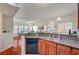 Open concept kitchen with granite countertops, wood cabinets, and stainless steel dishwasher at 689 Bay View Dr # 1311, Boulder City, NV 89005