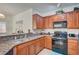 Functional kitchen offering granite countertops, wood cabinets, and a black gas range at 689 Bay View Dr # 1311, Boulder City, NV 89005