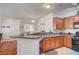 Well-lit kitchen boasting granite countertops, wooden cabinetry, and modern appliances at 689 Bay View Dr # 1311, Boulder City, NV 89005