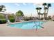 Sparkling community pool with lounge chairs, lush greenery, and palm trees at 689 Bay View Dr # 1311, Boulder City, NV 89005