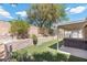 Landscaped backyard with mature trees and shrubs, featuring artificial turf and a hot tub at 6997 Ray Charles Ln, Las Vegas, NV 89119