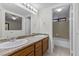 Bathroom featuring double sinks, granite countertops, and a shower and tub at 6997 Ray Charles Ln, Las Vegas, NV 89119