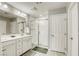 Clean bathroom with a double sink, a shower, and a door, tiled floors at 7061 Tilligerry St, North Las Vegas, NV 89084
