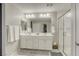 Clean bathroom with a double sink, a shower, and a door, tiled floors at 7061 Tilligerry St, North Las Vegas, NV 89084