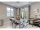 Elegant dining area featuring a wooden table set for six, flooded with natural light from sliding glass doors at 7061 Tilligerry St, North Las Vegas, NV 89084