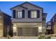Inviting two-story home featuring neutral stucco exterior, a two-car garage, and decorative window shutters, offering suburban charm at 7061 Tilligerry St, North Las Vegas, NV 89084
