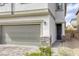 A beautifully designed home featuring a gray garage door and a meticulously landscaped entrance at 7061 Tilligerry St, North Las Vegas, NV 89084