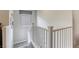 A well-lit stairway that is accented by white railings and neutral walls, leading to the upper level at 7061 Tilligerry St, North Las Vegas, NV 89084