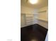 Spacious walk-in closet with dark floors and ample shelving for optimal organization and storage at 7518 Luna Del Rey St, Las Vegas, NV 89123