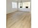 Bright living room featuring wood floors, a chandelier, and an opening to the fireplace and kitchen at 7615 Paso Robles Ave, Las Vegas, NV 89113