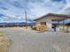 Desert property featuring a gravel driveway and structure with carport under a cloudy sky at 781 Buol Rd, Pahrump, NV 89048