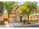 Inviting two-story townhome with drought-tolerant landscaping, an attached garage, and a vibrant green front door at 7923 Homer Ct, Las Vegas, NV 89139