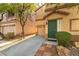 Stylish two-story townhome showcases low-maintenance landscaping, an attached garage, and an attractive green front door at 7923 Homer Ct, Las Vegas, NV 89139