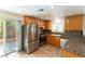 Well-equipped kitchen featuring stainless steel refrigerator, granite countertops, and access to the backyard at 7923 Homer Ct, Las Vegas, NV 89139