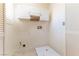 Functional laundry room features tile floors, overhead cabinets, and convenient utility connections at 7923 Homer Ct, Las Vegas, NV 89139