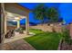Lush green backyard with a covered patio, hardscape and block wall at 8128 Devils Canyon St, North Las Vegas, NV 89085