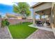 Lush green backyard with a covered patio, hardscape and block wall at 8128 Devils Canyon St, North Las Vegas, NV 89085