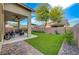 Lush green backyard with a covered patio, hardscape and block wall at 8128 Devils Canyon St, North Las Vegas, NV 89085