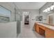 Bathroom showcasing double sinks, a glass shower, and a hallway leading to a bedroom at 8128 Devils Canyon St, North Las Vegas, NV 89085