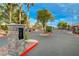 Gated community entrance with stone pillars, mature trees, and well-maintained landscaping at 8128 Devils Canyon St, North Las Vegas, NV 89085