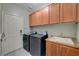A functional laundry room with washer, dryer, and ample cabinet space above the sink at 8128 Devils Canyon St, North Las Vegas, NV 89085