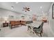 Bright and spacious living room with tile floors, a ceiling fan, dining area, and open layout at 8128 Devils Canyon St, North Las Vegas, NV 89085