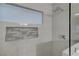 Modern glass shower features white marble tiling, a rainfall shower head, and a window at 8128 Devils Canyon St, North Las Vegas, NV 89085