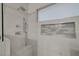Modern shower with white marble tiling, rainfall shower head, and niche at 8128 Devils Canyon St, North Las Vegas, NV 89085