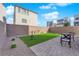 Backyard with artificial turf, desert landscaping, brick patio, and a seating area is perfect for outdoor entertaining at 8178 Eaton Hill St, Las Vegas, NV 89113
