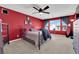 Cozy bedroom with red accent wall, ceiling fan, and ample natural light from the window at 8178 Eaton Hill St, Las Vegas, NV 89113