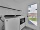 Well-lit laundry room features a washer, dryer, overhead shelf, and exterior door leading to the backyard at 8178 Eaton Hill St, Las Vegas, NV 89113