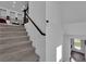 Carpeted staircase with a dark wood handrail, providing access to upper floors and connecting to an open living space at 8178 Eaton Hill St, Las Vegas, NV 89113