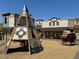 Charming playground featuring a unique pyramid climber and a classic covered wagon against a backdrop of themed storefronts at 8682 Gateway Glen Dr, Las Vegas, NV 89178