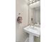 Well-lit half bathroom with a modern pedestal sink and decorative towel rack at 881 Barrhead Ave, Henderson, NV 89012