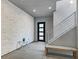 Modern entryway with a unique stone accent wall, bench, and staircase with metal railing at 881 Barrhead Ave, Henderson, NV 89012