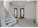 Welcoming entryway with a staircase, glass doors, seating, and modern finishes at 881 Barrhead Ave, Henderson, NV 89012