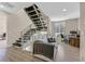 Contemporary living room with wood floors, metal staircase, and bright office space at 881 Barrhead Ave, Henderson, NV 89012