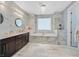 Luxurious bathroom featuring marble walls, a soaking tub, and modern fixtures for a spa-like experience at 881 Barrhead Ave, Henderson, NV 89012