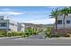 Inviting street view of modern homes nestled behind lush landscaping with palm trees and mountain views at 881 Barrhead Ave, Henderson, NV 89012