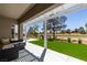 Relaxing covered patio with scenic golf course views, sleek furniture, and a well-maintained lawn at 9425 Villa Ridge Dr, Las Vegas, NV 89134