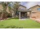 A well-maintained backyard featuring a covered patio and artificial grass for a low maintenance, green outdoor space at 9545 Parker Springs Ct, Las Vegas, NV 89166