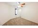 A clean, carpeted bedroom with neutral walls, ceiling fan, and a bright window at 9545 Parker Springs Ct, Las Vegas, NV 89166