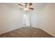 Carpeted bedroom with neutral walls, a ceiling fan, and access to another room via a white door at 9545 Parker Springs Ct, Las Vegas, NV 89166