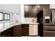 Close-up of kitchen island featuring granite countertops, stainless steel appliances, and dark wood cabinetry at 9545 Parker Springs Ct, Las Vegas, NV 89166