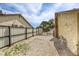 Side yard featuring gravel landscaping, a secure fence for privacy, and potential for a dog run at 1012 Winwood St, Las Vegas, NV 89108