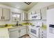 Corner kitchen features white cabinets, appliances, and a sunny window at 1012 Winwood St, Las Vegas, NV 89108