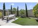 Backyard featuring a daybed, artificial grass, and privacy landscaping at 10297 Sierra Skye Ave, Las Vegas, NV 89166