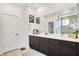 Bathroom featuring double sink vanity with modern fixtures, large mirror, and tiled floors at 10297 Sierra Skye Ave, Las Vegas, NV 89166