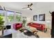 Bright living room featuring a vibrant red sofa and natural light from the windows at 10297 Sierra Skye Ave, Las Vegas, NV 89166